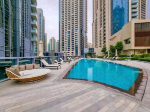 a swimming pool in the middle of a city with tall buildings at Luxurious 1BR in Opera Grand 5 mins walk to Burj Khalifa in Dubai