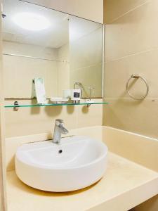 a bathroom with a white sink and a mirror at Cozy 1 Bedroom Condo Unit in Manila