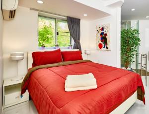 a bedroom with a red bed with a red blanket at LUXURIOUS APARTMENT on JOMTIEN BEACH ROAD in Jomtien Beach