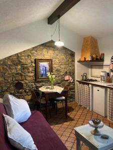 a kitchen with a table and a stone wall at Casa Didun -apart Bartume' in Dolcedo
