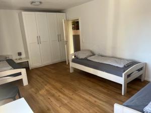 a bedroom with two beds in a room with wooden floors at Haus 6-16P - 6Zi - Aurora Hamburg in Buchholz in der Nordheide