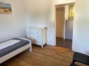 a bedroom with a bed and a dresser in it at Haus 6-16P - 6Zi - Aurora Hamburg in Buchholz in der Nordheide +4 photos