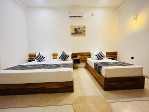 ein Schlafzimmer mit zwei Betten und einem Teppich in der Unterkunft Manju`s place in Ahangama