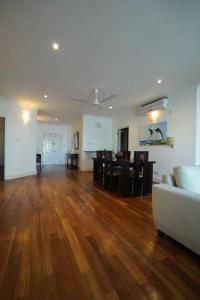 a living room with a white couch and a wooden floor at Colombo City 3 Bedroom Apartment with Pool Gym & Workdesk in Colombo