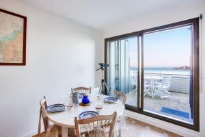 une salle à manger avec une table et une vue sur l'océan dans l'établissement Appartement avec balcon vue mer, pour 4 personnes, à Dinard
