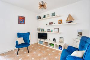 un salon avec deux chaises bleues et une cheminée dans l'établissement Appartement avec balcon vue mer, pour 4 personnes, à Dinard