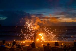 a crowd of people watching a fire show on the beach at InterContinental Phuket Resort by IHG in Kamala Beach