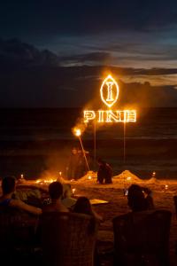 a group of people sitting on the beach at night at InterContinental Phuket Resort by IHG in Kamala Beach