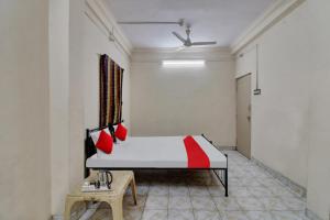 a bedroom with a bed with red pillows on it at Hotel O Kr Inn in Chandrapur +16 photos