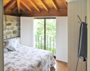 ein Schlafzimmer mit einem Bett und einem großen Fenster in der Unterkunft Charming House in Covelas with Shared Pool in Póvoa de Lanhoso + 33 Fotos