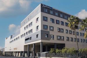 Un gran edificio blanco con un cartel en él. en Radisson Blu Hotel, Amman Galleria Mall, en Amán