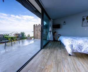 a bedroom with a bed and a view of the ocean at La Suite Soleil Romantique & Vue in Istres
