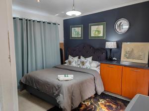 a bedroom with a bed with a blue wall at Private condo in secure area in Cape Town