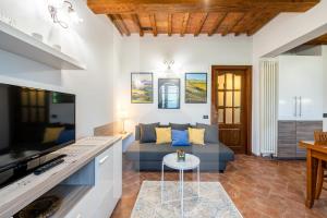 a living room with a couch and a table at Homiday - Tuscany House - Parcheggio e Giardino Privato in Pisa