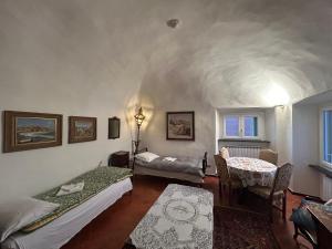 a room with two beds and a table and a window at NAPOLEONE vintage house in Imperia