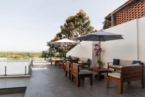 a row of tables and chairs with umbrellas on a patio at Suítes Luxo Marambaia- Epic House in Rio de Janeiro