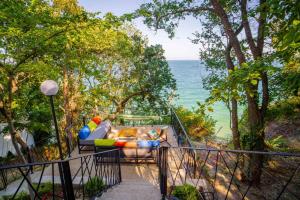 a couch sitting on a balcony overlooking the ocean at Къщички Синьо лято, Черноморец - Варна - Blue Summer Houses Varna in Varna City