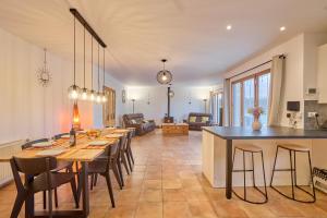 a kitchen and dining room with a long table and chairs at C'est la vie là ! Jolie maison avec piscine in Saint-Astier