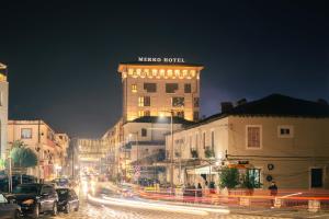 a building with a sign on top of it at night at MERKO HOTEL in Berat