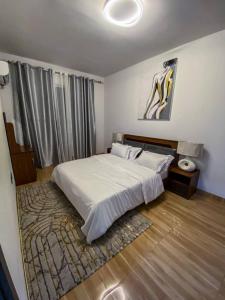 a bedroom with a white bed and a rug at pierre de lune in Kinshasa