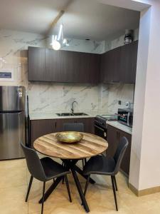 a kitchen with a wooden table and chairs in a kitchen at pierre de lune in Kinshasa