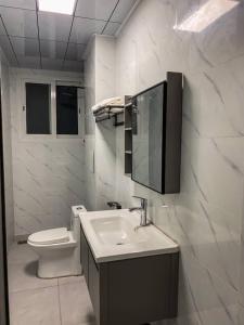 a white bathroom with a sink and a toilet at pierre de lune in Kinshasa