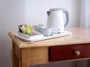 a table with a tea kettle and cups on it at Hostal Bianco in Madrid