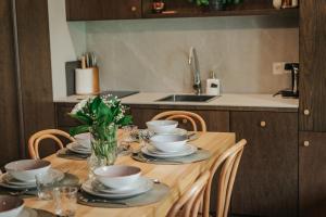 drewniany stół z talerzami, kubkami i kwiatami w obiekcie Jabłonki Resort&Spa w mieście Jabłonki