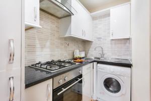 ロンドンにあるEuston Budget Apartments and Roomsのキッチン(コンロ、洗濯機付)