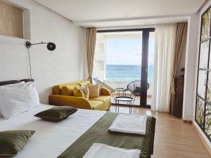 a bedroom with a bed and a view of the ocean at Olive Villas Beach Hotel in Sozopol