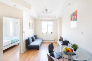 ロンドンにあるEuston Budget Apartments and Roomsのリビングルーム(ガラステーブル、ソファ付)