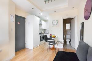 ロンドンにあるEuston Budget Apartments and Roomsの部屋にテーブルと椅子のあるキッチン