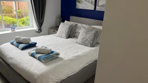 a white bed with two pillows on it with a window at Sunrise Cove, The Bay, Filey in Filey +30 photos