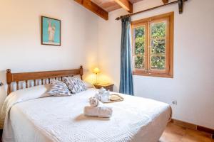 a bedroom with a white bed with a window at Villa Rosa in Pollença +22 photos
