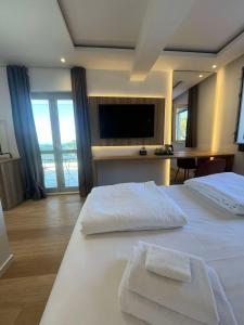 a hotel room with two beds and a flat screen tv at Dela in Hvar