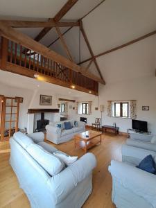 Una sala de estar con sofás blancos y una chimenea. en Church Farm Barns, en Thurgarton