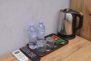 a tray with water bottles on a table with a coffee pot at Resident Hotel in Tashkent