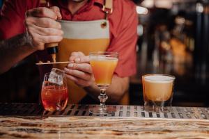 a bartender is preparing cocktails at a bar at Andaz Amsterdam, Prinsengracht, By Hyatt in Amsterdam