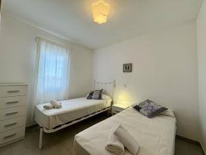 a bedroom with two beds and a dresser and a window at Villa Son Saura in Cala en Forcat
