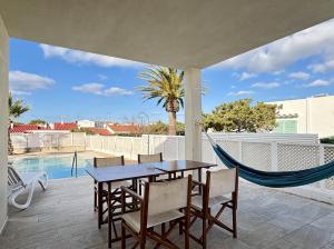 a patio with a table and chairs and a hammock at Villa Son Saura in Cala en Forcat