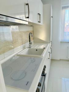 a white kitchen with a sink and a microwave at Golden Hour Apartment in Kaiserslautern +13 photos