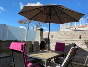 a table and two chairs with an umbrella at Spacious house next to the mill! in Westkapelle