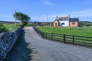 a gravel road next to a fence and a house at Armadale Farm Cottage in Armadale