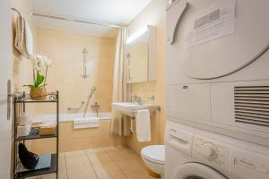 Un baño blanco con lavabo e inodoro. en Los Lorentes Residences Bulle, en Bulle