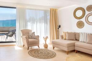 a living room with a couch and a chair and a window at Olive Villas Beach Hotel in Sozopol