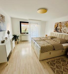 a white bedroom with a bed and a window at Golden Hour Apartment in Kaiserslautern