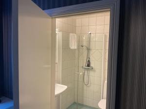 a bathroom with a shower and a sink at Hotell Örnen in Torsby +35 photos