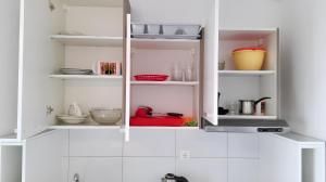 a kitchen with white shelves with dishes and utensils at Charming apartment with sea view in Sumartin - 27 sqm in Sumartin +40 photos