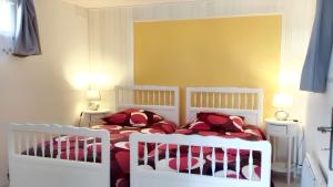 una camera da letto con due culle bianche in una stanza di Maison charmante à Trédaniel avec jardin et terrasse a Trédaniel