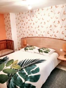 una camera da letto con un letto e carta da parati verde di Maison charmante à Trédaniel avec jardin et terrasse a Trédaniel